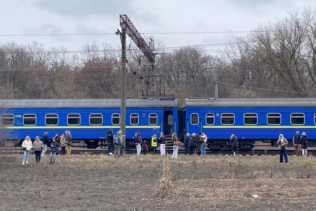 Passengers wait outside their sleeper train during an ongoing air alert of Russian drones at an undisclosed location in Ukraine on March 29, 2026, amid Russian invasion in Ukraine. The Ukrainian railways recently introduced evacuations from trains after Russia intensified its strikes on railway and in particular passenger trains. (Photo by Ania TSOUKANOVA / AFP)