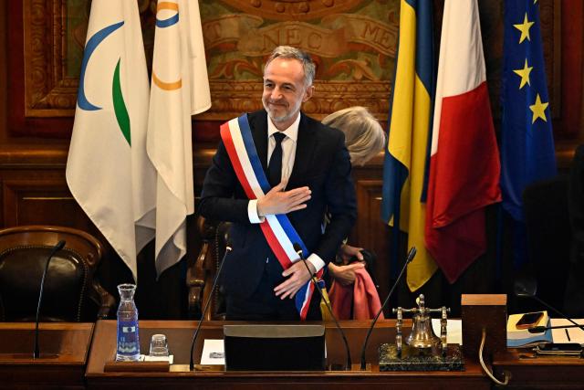 Paris' newly elected Mayor Emmanuel Grégoire wearing tricolour mayoral sash after being nominated greets the council during the inaugural city council session at the city hall of Paris on March 29, 2026. Emmanuel Grégoire, who was elected mayor of Paris by a wide margin over right wing candidate Rachida Dati, takes office on March 29, 2026 at the Paris City Hall to succeed Anne Hidalgo, who is stepping down after 12 years in office. (Photo by JULIEN DE ROSA / AFP)