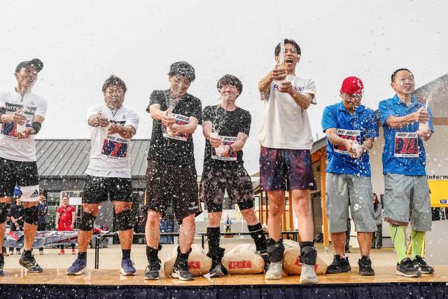 Winners celebrate on the stage after the ISU-1 Grand Prix in Kyotanabe, Kyoto prefecture on March 29, 2026. The ISU-1 Grand Prix is an endurance race supervised by the Japan Office Chair Racing Association (JORA), in which participants compete to see how many laps they can complete on office chairs over two hours. The event originated in 2010 in the Kirara shopping district of Kyotanabe, Kyoto Prefecture, and is now held at more than 20 locations across Japan. (Photo by Yuichi YAMAZAKI / AFP)