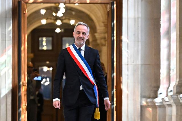 Paris' newly elected Mayor Emmanuel Grégoire wears the tricolour mayoral sash after being nominated during the inaugural city council session at the city hall of Paris on March 29, 2026. Emmanuel Grégoire, who was elected mayor of Paris by a wide margin over right wing candidate Rachida Dati, takes office on March 29, 2026 at the Paris City Hall to succeed Anne Hidalgo, who is stepping down after 12 years in office. (Photo by JULIEN DE ROSA / POOL / AFP)