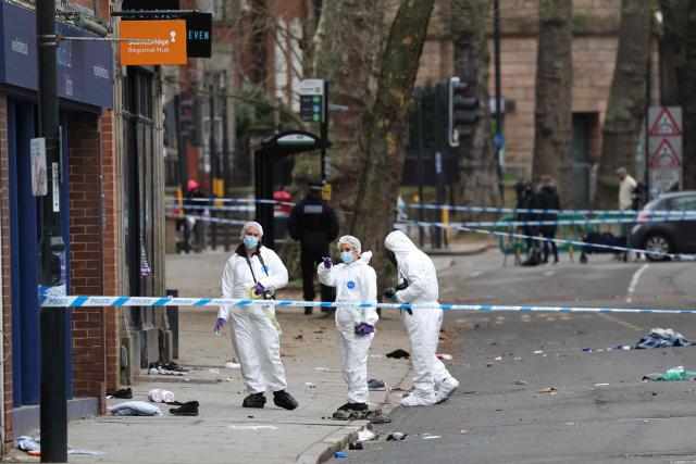 Police forensic officers work amongst a variety of personal items seen covering the road, inside a cordon set up on Friar Gate in central Derby, central England on March 29, 2026, following an incident the night before where a vehicle was driven into pedestrians. British police said they arrested a man after a car struck several pedestrians in a city in central England on Saturday night, leaving some victims seriously injured. (Photo by Darren Staples / AFP)