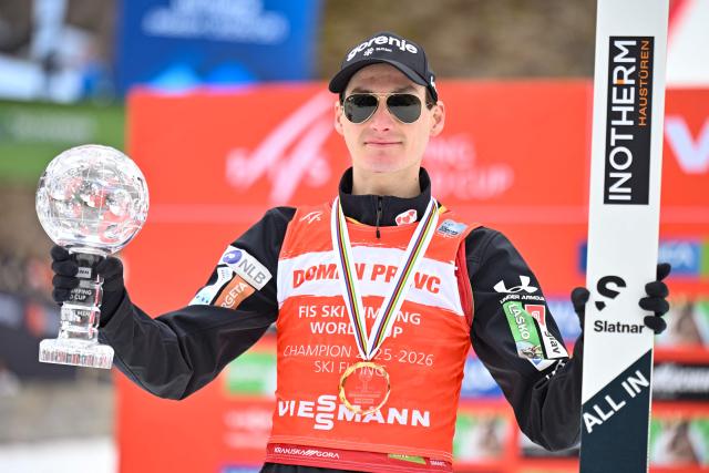 Slovenia's Domen Prevc celebrates his first place in the Ski Flying classification with the crystal globe on the podium after the Men's Individual Large Hill event at the FIS Jumping World Cup in Planica on March 29, 2026. (Photo by JURE MAKOVEC / AFP)