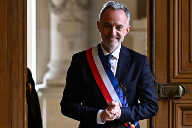 Paris' newly elected Mayor Emmanuel Grégoire, wearing his tricolour mayoral sash, arrives to speak to journalists after the inaugural city council session at the city hall of Paris on March 29, 2026. Emmanuel Grégoire, who was elected mayor of Paris by a wide margin over right wing candidate Rachida Dati, takes office on March 29, 2026 at the Paris City Hall to succeed Anne Hidalgo, who is stepping down after 12 years in office. (Photo by JULIEN DE ROSA / AFP)