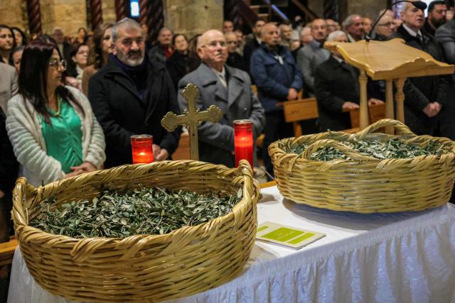 Baskets of olive branches are placed before faithful attending the Palm Sunday service at the Maronite Church of Saint George in the southern Lebanese border Christian village of Qlayaa on March 29, 2026. Qlayaa's local parish priest, Father Pierre Rai, was died on March 9 of wounds sustained from Israeli tank fire, sparking anger and fear. Lebanon was drawn into the Middle East war last week when Iran-backed militant group Hezbollah attacked Israel in response to the killing of the Iranian supreme leader during US-Israeli strikes on February 28. (Photo by AFP)