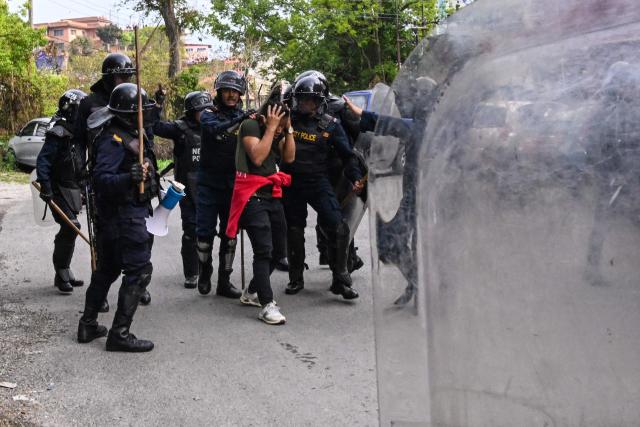 Police personnel clash with supporters of Nepal's former prime minister Khadga Prasad Sharma Oli, to protest against his arrest in Kathmandu on March 29, 2026. Oli appeared in court via video-link from a hospital on March 29 after his arrest for his alleged role in a deadly crackdown on the 2025 protests that ousted him. (Photo by Prakash MATHEMA / AFP)