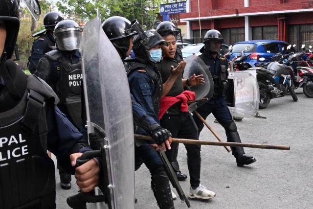 Police personnel detain a supporter of Nepal's former prime minister Khadga Prasad Sharma Oli, as they clash during a protest against his arrest in Kathmandu on March 29, 2026. Oli appeared in court via video-link from a hospital on March 29 after his arrest for his alleged role in a deadly crackdown on the 2025 protests that ousted him. (Photo by Prakash MATHEMA / AFP)