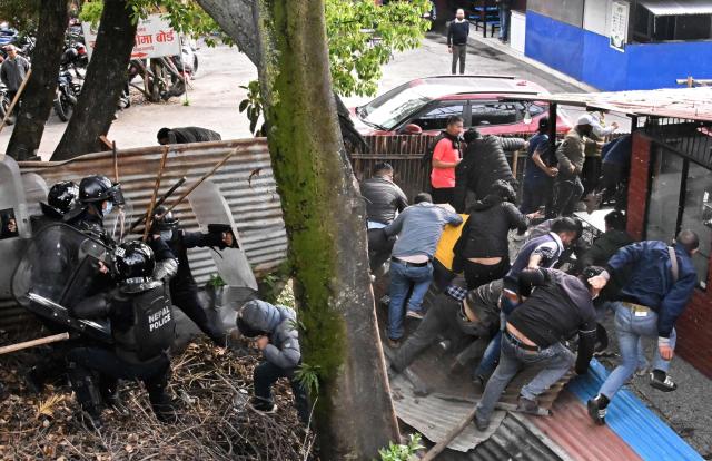 Police personnel clash with supporters of Nepal's former prime minister Khadga Prasad Sharma Oli, during a protest against his arrest in Kathmandu on March 29, 2026. A Nepal court on March 29 extended by five days the detention of Oli and his home minister after their arrest over alleged involvement in a deadly crackdown on the 2025 protests that ousted him. (Photo by Prakash MATHEMA / AFP)