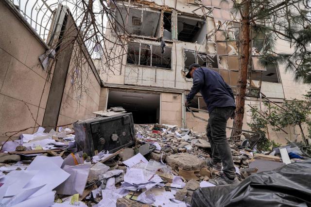 A man searches the debris outside an office building that housed the offices of the Doha-headquartered news network Al Araby TV following a missile strike earlier in the day in Tehran on March 29, 2026. The network on March 29 criticised a strike on the building hosting its Tehran office, as Israel and the US pressed an aerial campaign against Iran. It added that, according to the Iranian Red Crescent 10 people, had been injured in the Sunday morning strike. (Photo by ATTA KENARE / AFP) / 