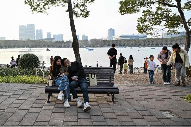 People visit the Century Park in Shanghai on March 29, 2026. (Photo by Hector RETAMAL / AFP)
