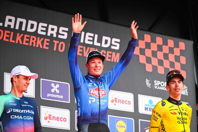 Belgian Jasper Philipsen of Alpecin-Premier Tech flanked by Danish Tobias Lund Andresen of Decathlon CMA CGM Team (L) and French Christophe Laporte of Team Visma-Lease a Bike (R), celebrates on the podium after the men elite 'Middelkerke-Wevelgem - In Flanders Fields' one day cycling race, 240.8 km from Middelkerke to Wevelgem, March 29, 2026. (Photo by ELIAS ROM / Belga / AFP) / Belgium OUT