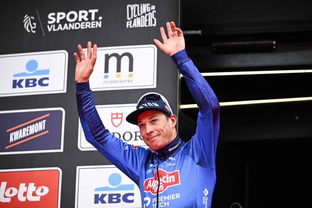 Belgian Jasper Philipsen of Alpecin-Premier Tech waves to the crowd on the podium after winning the men’s elite “Middelkerke–Wevelgem – In Flanders Fields” one-day cycling race, covering 240.8 km from Middelkerke to Wevelgem, on March 29, 2026. (Photo by JASPER JACOBS / Belga / AFP) / Belgium OUT