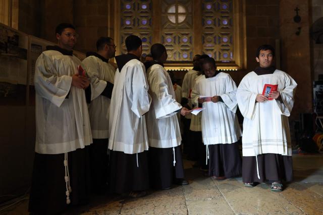 Members of the clergy stand on the day of a prayer service in the Church of All Nations held by Latin Patriarch of Jerusalem, Cardinal Pierbattista Pizzaballa, to mark Palm Sunday in Jerusalem on March 29, 2026, following the cancellation of the traditional Palm Sunday procession from the Mount of Olives amid restrictions on gathering in large groups and the US-Israeli war on Iran. Israeli authorities have cancelled the Palm Sunday procession in Jerusalem due to wartime restrictions. Israel has been at war since it and the US launched strikes against Iran on February 28, sparking swift retaliation by the Islamic republic which responded with missile attacks across the region. (Photo by Ammar Awad / POOL / AFP)