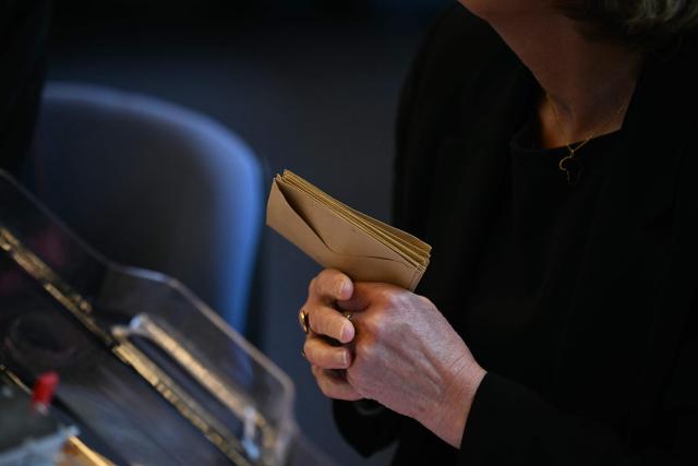 An attendee holds ballots during the inaugural city council session at the city hall of Le Blanc-Mesnil, on the outskirts of Paris, on March 29, 2026. (Photo by Blanca CRUZ / AFP)