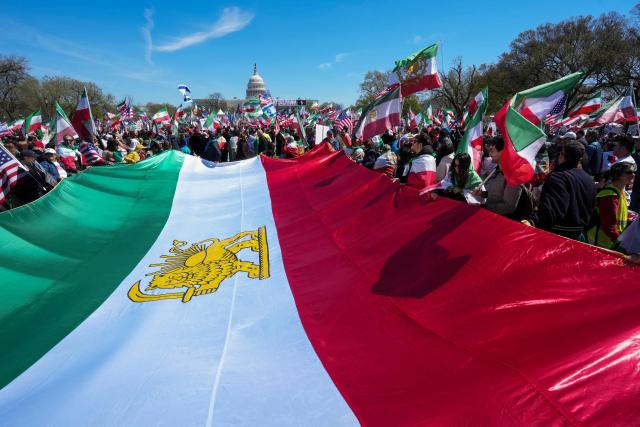 Demonstrators carry a large Iranian pre-1979 Islamic Revolution flag as they rally in support of Iranians' fight for freedom, on the National Mall in Washington, DC, on March 29, 2026. The event, organized by DCProtests4Iran, brought together members of the Iranian diaspora from the Washington, DC metropolitan area and surrounding states. (Photo by Ken Cedeno / AFP)