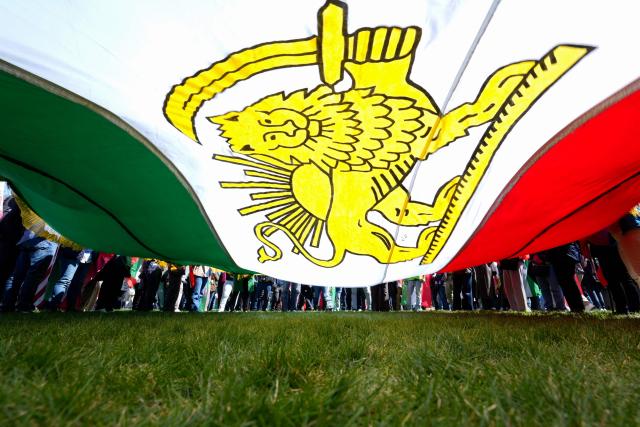 Demonstrators carry a large Iranian pre-1979 Islamic Revolution flag as they rally in support of Iranians' fight for freedom, on the National Mall in Washington, DC, on March 29, 2026. The event, organized by DCProtests4Iran, brought together members of the Iranian diaspora from the Washington, DC metropolitan area and surrounding states. (Photo by Ken Cedeno / AFP)