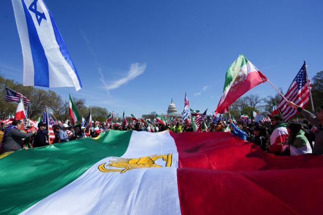 Demonstrators carry a large Iranian pre-1979 Islamic Revolution flag as they rally in support of Iranians' fight for freedom, on the National Mall in Washington, DC, on March 29, 2026. The event, organized by DCProtests4Iran, brought together members of the Iranian diaspora from the Washington, DC metropolitan area and surrounding states. (Photo by Ken Cedeno / AFP)
