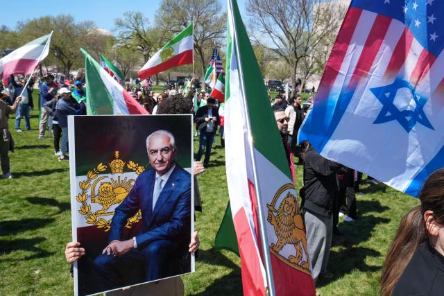 A demonstrator holds a portrait of Reza Pahlavi, son of the last shah of Iran, during a rally in support of Iranians' fight for freedom, on the National Mall in Washington, DC, on March 29, 2026. The event, organized by DCProtests4Iran, brought together members of the Iranian diaspora from the Washington, DC metropolitan area and surrounding states. (Photo by Ken Cedeno / AFP)