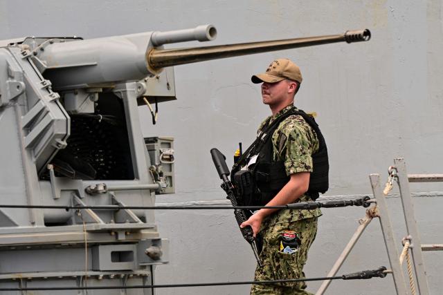 A soldier stands guard on the deck of the US Navy Arleigh Burke-class guided-missile destroyer USS Gridley (DDG 101), docked at the Amador cruise terminal in Panama City on March 29, 2026. The ship reached the country alongside the aircraft carrier USS Nimitz as part of the multinational maritime cooperation exercises “Mares del Sur 2026.” (Photo by MARTIN BERNETTI / AFP)