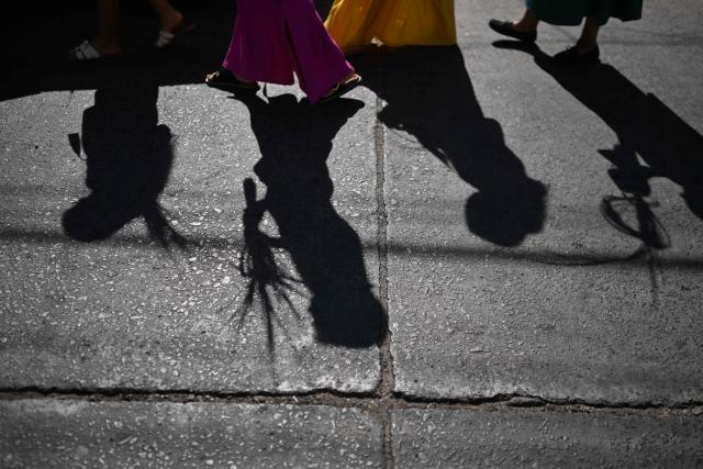 Silhouettes of Catholic faithful are seen during the Palm Sunday celebration at the beginning of Holy Week in Suchitoto, El Salvador, on March 29, 2026. (Photo by Marvin RECINOS / AFP)