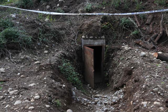 (FILES) View of the entrance of one of the bunkers used by cult leader former Wehmacht soldier Paul Schaefer in Colonia Dignidad (Dignity Colony), now called Villa Baviera, near Parral, Maule Province, Chile on April 15, 2025. Chile's new right-wing government will reverse plans to expropriate Colonia Dignidad, a German-themed settlement that served as a torture center when Augusto Pinochet was in power, a government minister said on March 29, 2026. The place featured a swimming pool, manicured lawns, and lush forest backdrop, making it look like a nice holiday getaway spot. (Photo by RODRIGO ARANGUA / AFP)