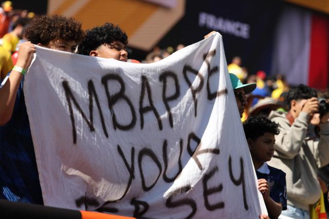 Football fans hold a banner to request France's forward #10 Kylian Mbappe's jersey before the start of a friendly football match between Colombia and France at Northwest Stadium in Landover, Maryland, on March 29, 2026. (Photo by FRANCK FIFE / AFP)