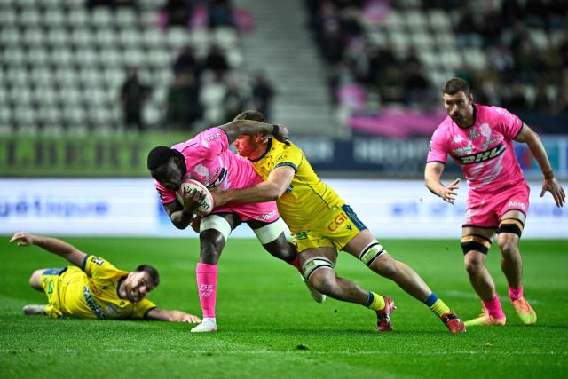 Stade Français' French number 8 Yoan Tanga (CL) is tackled as he runs with the ball during the French Top14 rugby union match between Stade Francais Paris and ASM Clermont Auvergne at the Jean-Bouin Stadium in Paris on March 29, 2026. (Photo by JULIEN DE ROSA / AFP)