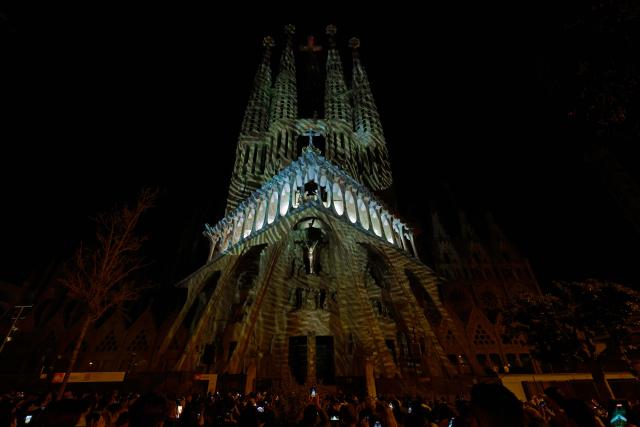 TOPSHOT - Lights illuminate the Passion facade (western side) of the Sagrada Familia basilica, during a music and light show narrating the passion and death of Jesus Christ, in Barcelona, on March 29, 2026, marking the start of the Holy Week. (Photo by Lluis GENE / AFP)