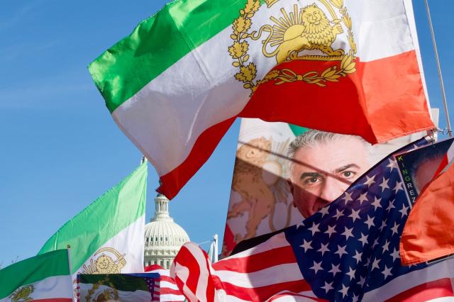 Demonstrators wave Iranian pre-1979 Islamic Revolution and US flags and hold up an image of Reza Pahlavi, son of the last shah of Iran, as they march during a rally in support of Iranians' fight for freedom, near the US Capitol in Washington, DC, on March 29, 2026. The event, organized by DCProtests4Iran, brought together members of the Iranian diaspora from the Washington, DC metropolitan area and surrounding states. (Photo by Amid FARAHI / AFP)