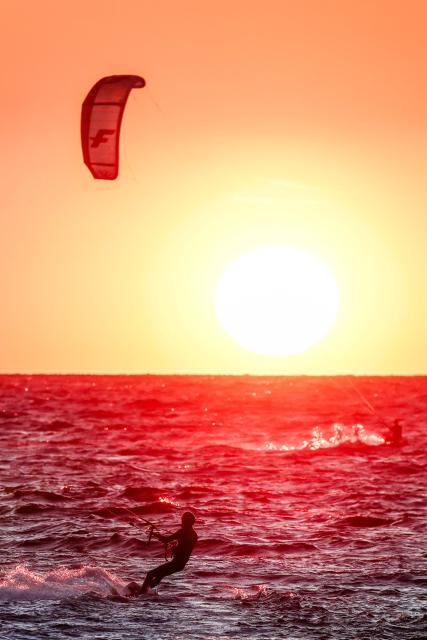 Kitesurfers surf as the sun sets in Marseille, south-eastern France on March 29, 2026. (Photo by Thibaud MORITZ / AFP)