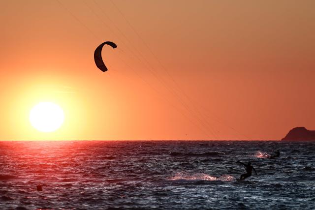 Kitesurfers surf as the sun sets in Marseille, south-eastern France on March 29, 2026. (Photo by Thibaud MORITZ / AFP)