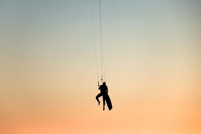 A kitesurfer soars into the air above sea as the sun sets in Marseille, south-eastern France on March 29, 2026. (Photo by Thibaud MORITZ / AFP)