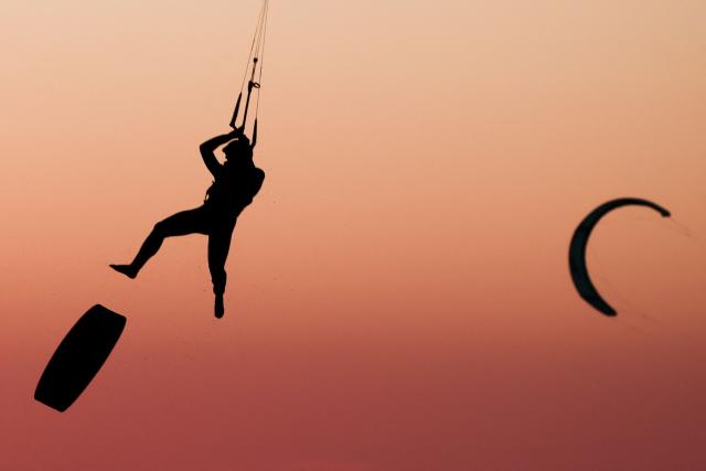 A kitesurfer soars into the air above sea as the sun sets in Marseille, south-eastern France on March 29, 2026. (Photo by Thibaud MORITZ / AFP)