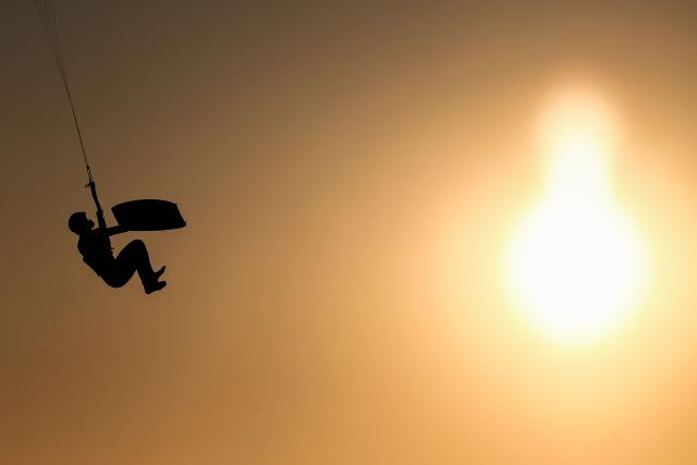 A kitesurfer soars into the air above sea as the sun sets in Marseille, south-eastern France on March 29, 2026. (Photo by Thibaud MORITZ / AFP)