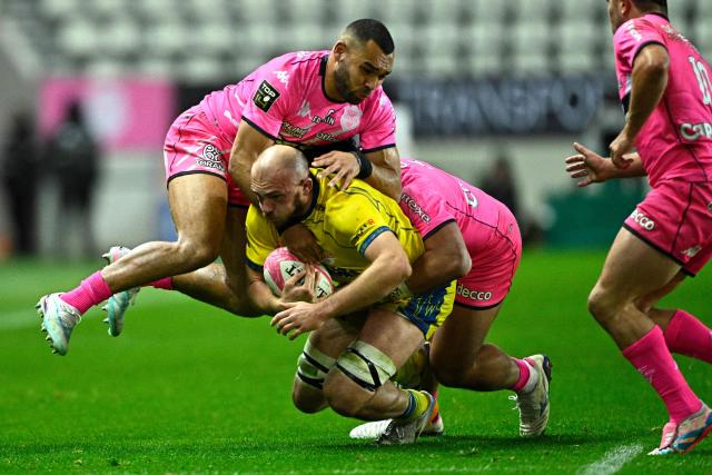 Clermont's French flanker Anthime Hemery (C) is tackled by Stade Français' English center Joe Marchant (CL) and Stade Français' French center Tani Vili (CR) during the French Top14 rugby union match between Stade Francais Paris and ASM Clermont Auvergne at the Jean-Bouin Stadium in Paris on March 29, 2026. 11, 12 (Photo by JULIEN DE ROSA / AFP)