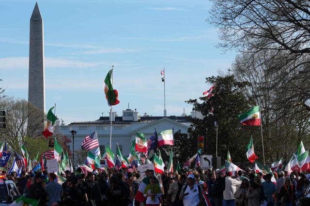 The Washington Monument is seen in the distance (L) as demonstrators wave Iranian pre-1979 Islamic Revolution and US flags as they march toward the White House during a rally in support of Iranians' fight for freedom, in Washington, DC, on March 29, 2026. The event, organized by DCProtests4Iran, brought together members of the Iranian diaspora from the Washington, DC metropolitan area and surrounding states. (Photo by Ken Cedeno / AFP)