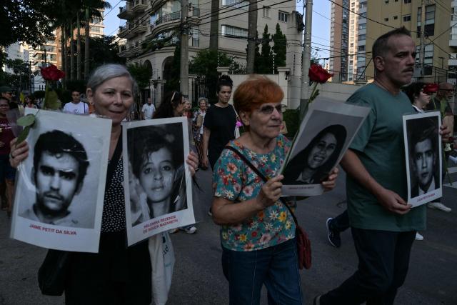 Relatives and social activists attend a silent march in memory of the victims of state violence during the 1964 dictatorship in Sao Paulo, Brazil on March 29, 2026. (Photo by NELSON ALMEIDA / AFP)