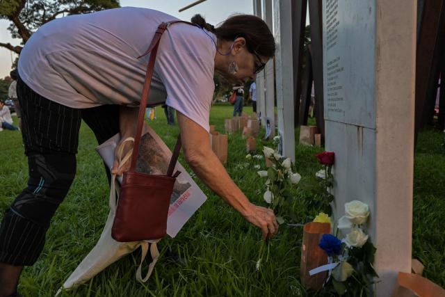 A woman places flowers at a monument in memory of the victims of state violence under the 1964 dictatorship during a silent march in São Paulo, Brazil, on March 29, 2026. (Photo by NELSON ALMEIDA / AFP)