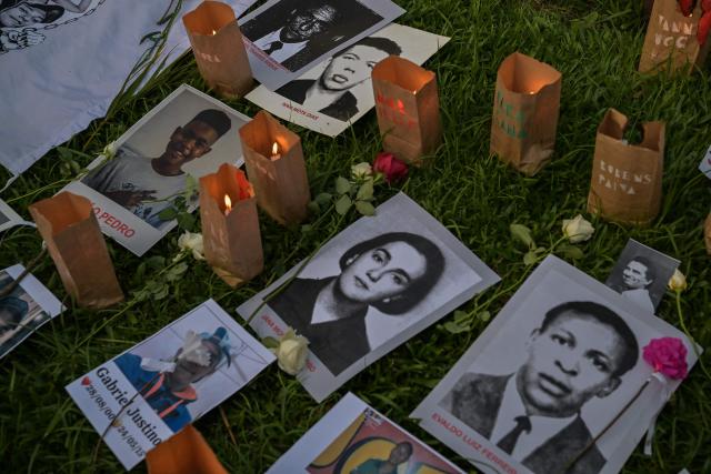 This view shows images and candles in memory of the victims of state violence under the 1964 dictatorship during a silent march in Sao Paulo, Brazil, on March 29, 2026. (Photo by NELSON ALMEIDA / AFP)