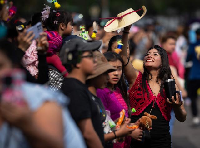 A woman spins her hat during the annual spring carnival parade in Mexico City on March 29, 2026. (Photo by Carl de Souza / AFP)