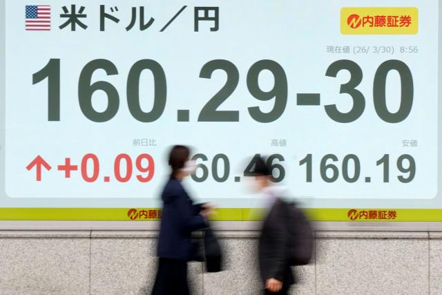 An electronic quotation board displaying the foreign exchange rate of the Japanese yen against the US dollar along a street in Tokyo on March 30, 2026. Japan's Nikkei tumbled over five percent in early trade March 30 and South Korea's Kospi was down more than four percent after the price of oil rose again with no end in sight for the war in the Middle East. (Photo by Kazuhiro NOGI / AFP)