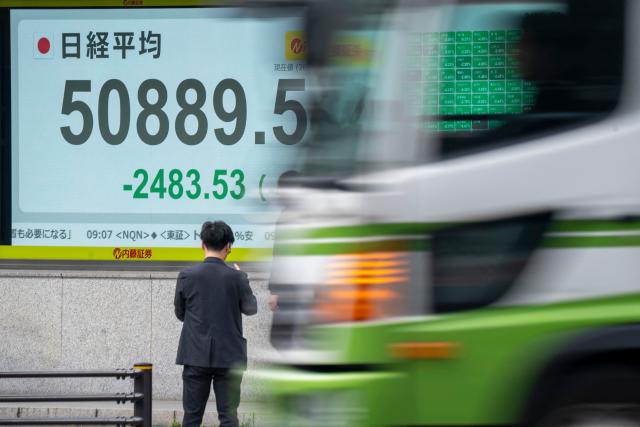 An electronic quotation board displays the Nikkei Stock Average on the Tokyo Stock Exchange along a street in Tokyo on March 30, 2026. Japan's Nikkei tumbled over five percent in early trade March 30 and South Korea's Kospi was down more than four percent after the price of oil rose again with no end in sight for the war in the Middle East. (Photo by Kazuhiro NOGI / AFP)