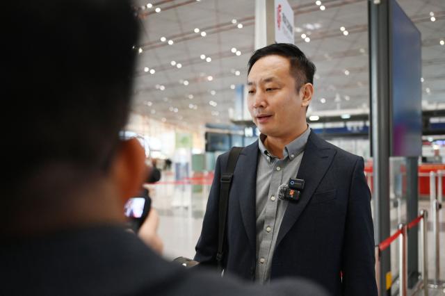 Zhao Bin, a Chinese business traveller, speaks to media after checking in for a flight to Pyongyang, North Korea, at Beijing airport on March 30, 2026. Air China restarted direct flights between Beijing and Pyongyang on Marach 30 after a six-year hiatus, another sign isolated North Korea is gradually opening up following the resumption of train services between the capitals. (Photo by GREG BAKER / AFP)