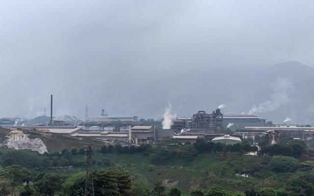 This aerial photo taken on March 19, 2026, shows the Duc Giang Lao Cai Chemical Plant in the Tang Loong industrial Park, Lao Cai Province, northern Vietnam. Grey and white smoke around the clock, dust-covered trees and nonstop noise: residents living next to Vietnam's biggest chemical production complex coexist with toxic fumes from the factories. (Photo by Nhac NGUYEN / AFP) / TO GO WITH AFP STORY: Vietnam-environment-chemicals-crime, FOCUS by Tran Thi Minh Ha, with Matt Surrusco in Bangkok