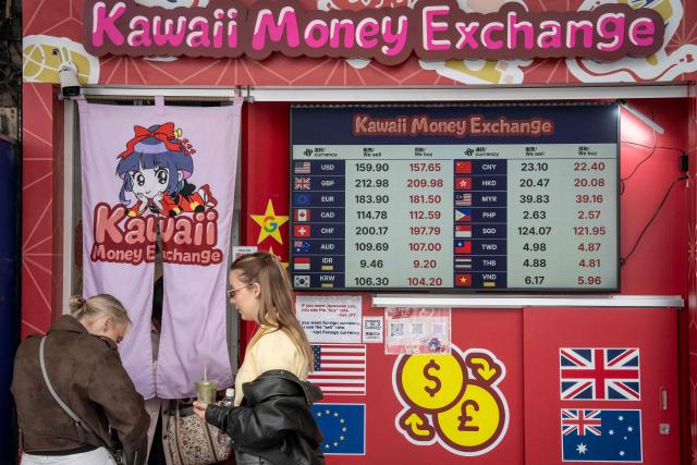 People queue in front of a currency exchange shop in Tokyo on March 30, 2026. (Photo by Yuichi YAMAZAKI / AFP)