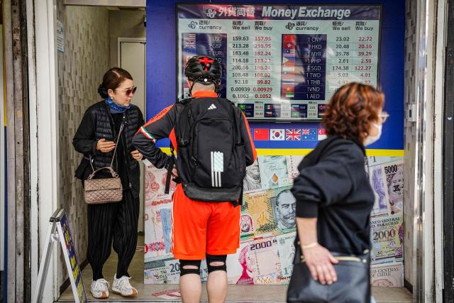 People visit a currency exchange shop in Tokyo on March 30, 2026. (Photo by Yuichi YAMAZAKI / AFP)