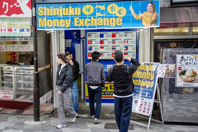 People queue in front of a currency exchange shop in Tokyo on March 30, 2026. (Photo by Yuichi YAMAZAKI / AFP)