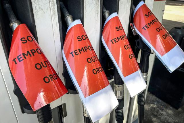 Signs cover petrol bowsers at a closed petrol station in Sydney on March 30, 2026. Australia will halve a tax on fuel to reduce costs for motorists experiencing soaring petrol prices due to war in the Middle East, Prime Minister Anthony Albanese said on March 30, 2026. (Photo by DAVID GRAY / AFP)
