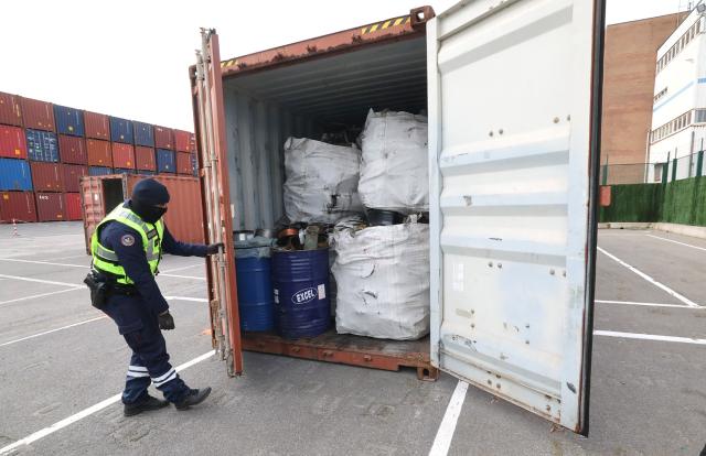 Customs officers inspect a shipping container at the port of Dunkirk in Loon-Plage on March 27, 2026, following a recent record seizure of 13 tons of cocaine from South America. (Photo by Francois LO PRESTI / AFP)