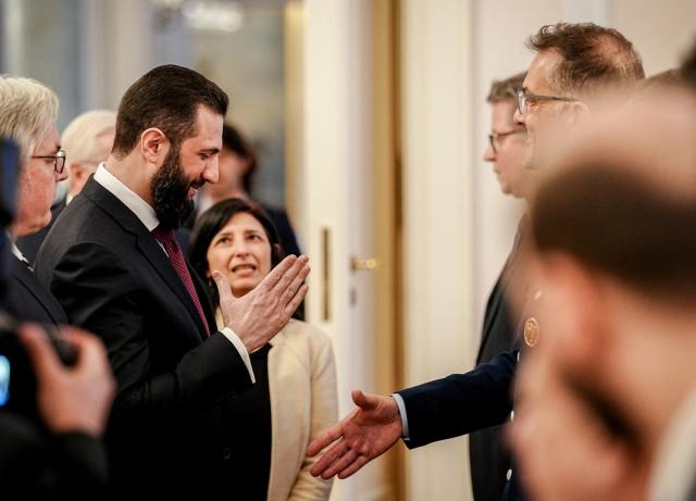 Syrian President Ahmed al-Sharaa (2L) is welcomed at the Bellevue presidential palace in Berlin on March 30, 2026. Syria's President Ahmed al-Sharaa visits Germany on Monday for talks on the Middle East war, rebuilding his country and Berlin's efforts to send back Syrian refugees. (Photo by Kay Nietfeld / POOL / AFP)