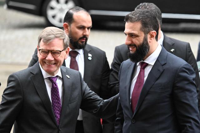 Syrian President Ahmed al-Sharaa (R) is welcomed by German Foreign Minister Johann Wadephul (L) ahead a German-Syrian roundtable meeting on economy at the Foreign Ministry in Berlin on March 30, 2026. Syria's President Ahmed al-Sharaa visits Germany on Monday for talks on the Middle East war, rebuilding his country and Berlin's efforts to send back Syrian refugees. (Photo by RALF HIRSCHBERGER / AFP)